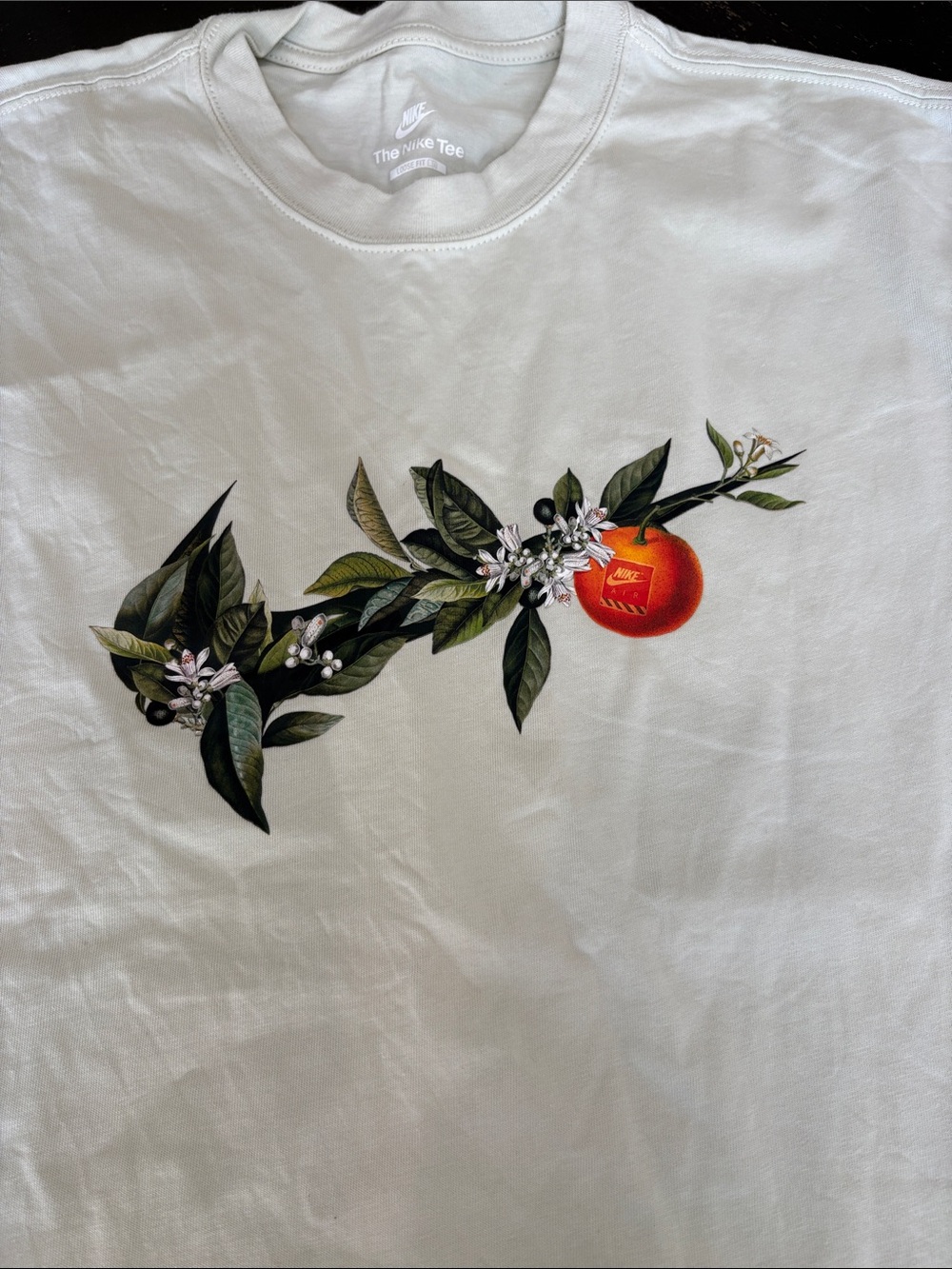 Nike White Tee with Green Floral Swoosh and Orange Fruit